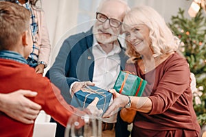 happy grandparents presenting beautiful gifts