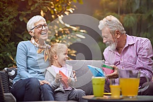 Happy grandparents spending time with  granddaughter. Family generations concept
