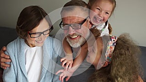 Happy grandparents and two granddaughters. Close Indoor portrait. Grandpa and Grandma laugh and have fun with two little