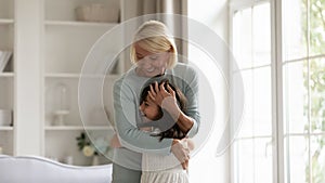 Happy granny and small granddaughter play together at home