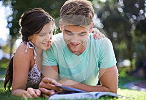 Happy, grass and couple with books for reading, learning and studying together outdoors at college. University