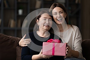 Happy grateful grownup daughter and senior mom celebrating mothers day