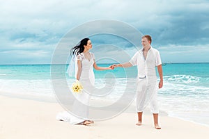 Happy groom and bride on the sandy tropical beach. Wedding and h