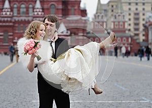 Happy groom holding beautiful bride