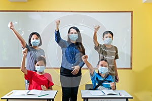 Happy group of asian teacher and children studying in classroom with face mask back at school after covid-19 quarantine and