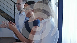 Happy group of business people clapping in office