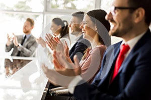 Happy group of businesspeople clapping in office