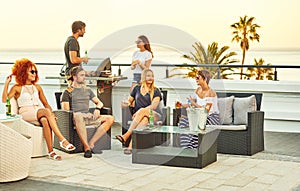 Happy group of close friends socialising together on a rooftop