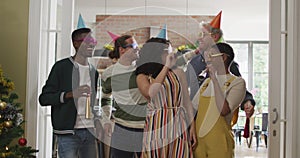 Happy group of diverse friends in party hats celebrating together