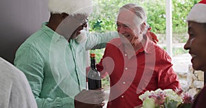 Happy group of diverse senior friends welcoming in doorway at christmas time