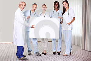 Happy group of doctors holding a blank placard