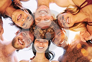 Happy group of friends in circle under the sun in the summertime