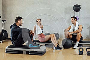 Happy group of friends have a conversation during a break at gym.