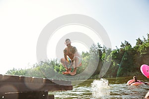 Happy group of friends having fun, laughting and swimming in river