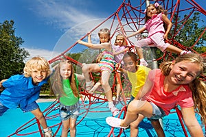 Happy group of kids on red ropes together in park