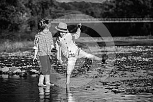 Happy group little girl and boy child having fun to playing in the river in summer time. Summer camp for kids. vacation