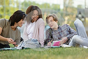 Happy group of multiethnic students studying outdoors