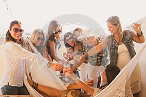 Happy group of people in friendship enjoying a party on the terrace toasting with red wine. Beautiful women. Simplicity and