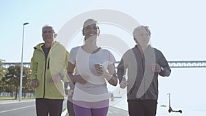 Happy group of people jogging together outdoors