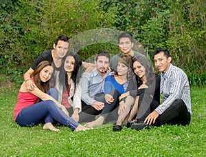 Happy group of students sitting at the park