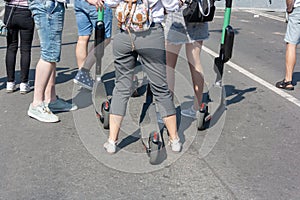 Happy group of tourists with electric scooters talking