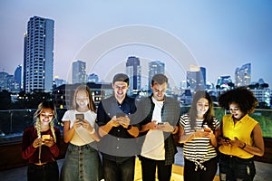 Happy group of young adults using smartphones