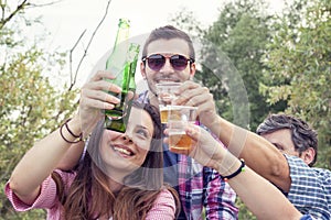 Happy group of young friends toasting with beer