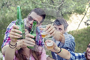 Happy group of young friends toasting with beer