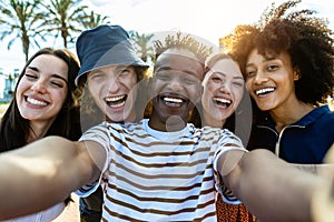 Happy group of young multiracial friends having fun taking selfie outdoors