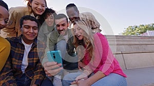 Happy group of young people having fun using smartphone outdoors