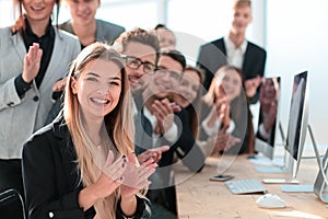 Happy group of young professionals applauding their success.