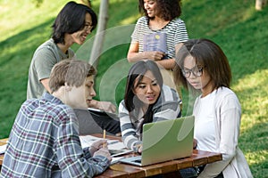 Happy group of young students sitting and studying