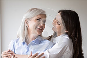 Happy grown-up daughter embracing her mother with love