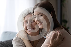 Happy grownup daughter and mature mom hugging