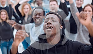 happy guy against the background of a cheering group of young people