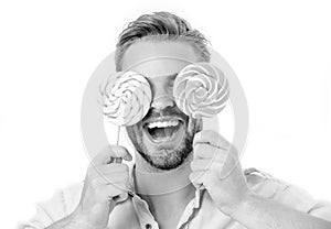 Happy guy with candy glasses isolated on white background. Man smile with lollipop on sticks. Summer. Food and snack photo