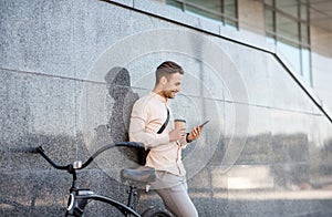 Happy guy with cup of coffee surfing at smartphone