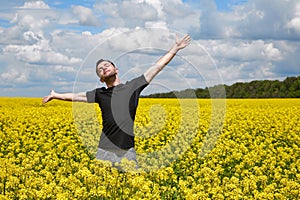 Happy guy enjoying life without pollen allergy in a rapeseed field