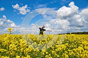 Happy guy enjoying life without pollen allergy in a rapeseed field