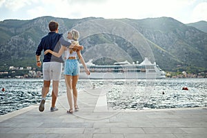 Happy guy and girl. Lovers enjoy each other. Loving couple hugging on the pier. Summertime holiday fun. Travel, love, fun,