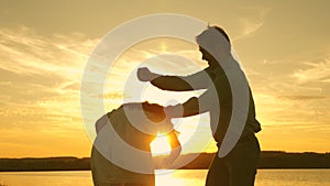 Happy guy and girl waltz in the evening in the summer park. Loving man and woman dance in bright rays of sun on the