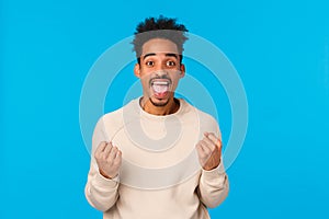 Happy guy got huge chance, winning lottery, got employed awesome company. Attractive african-american male celebrting photo
