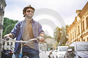 Happy guy in hat riding bicycle