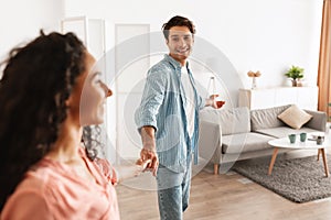 Happy guy inviting lady to enter home