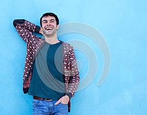 Happy guy laughing against blue background