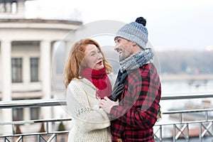 Happy guy looks to woman. Urban couple date on bridge. Red hair woman meet smiling guy. woman and laughing men on city background