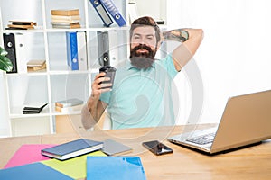 Happy guy relaxing in office during coffee break, relaxation