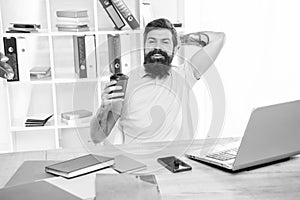 Happy guy relaxing in office during coffee break, relaxation