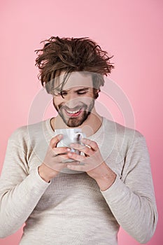 Happy guy with tea cup on pink background.