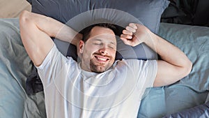 Happy Guy Waking Up Lying In Bed At Home, Top-View